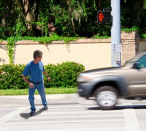 man walking at cross walk missing oncoming car