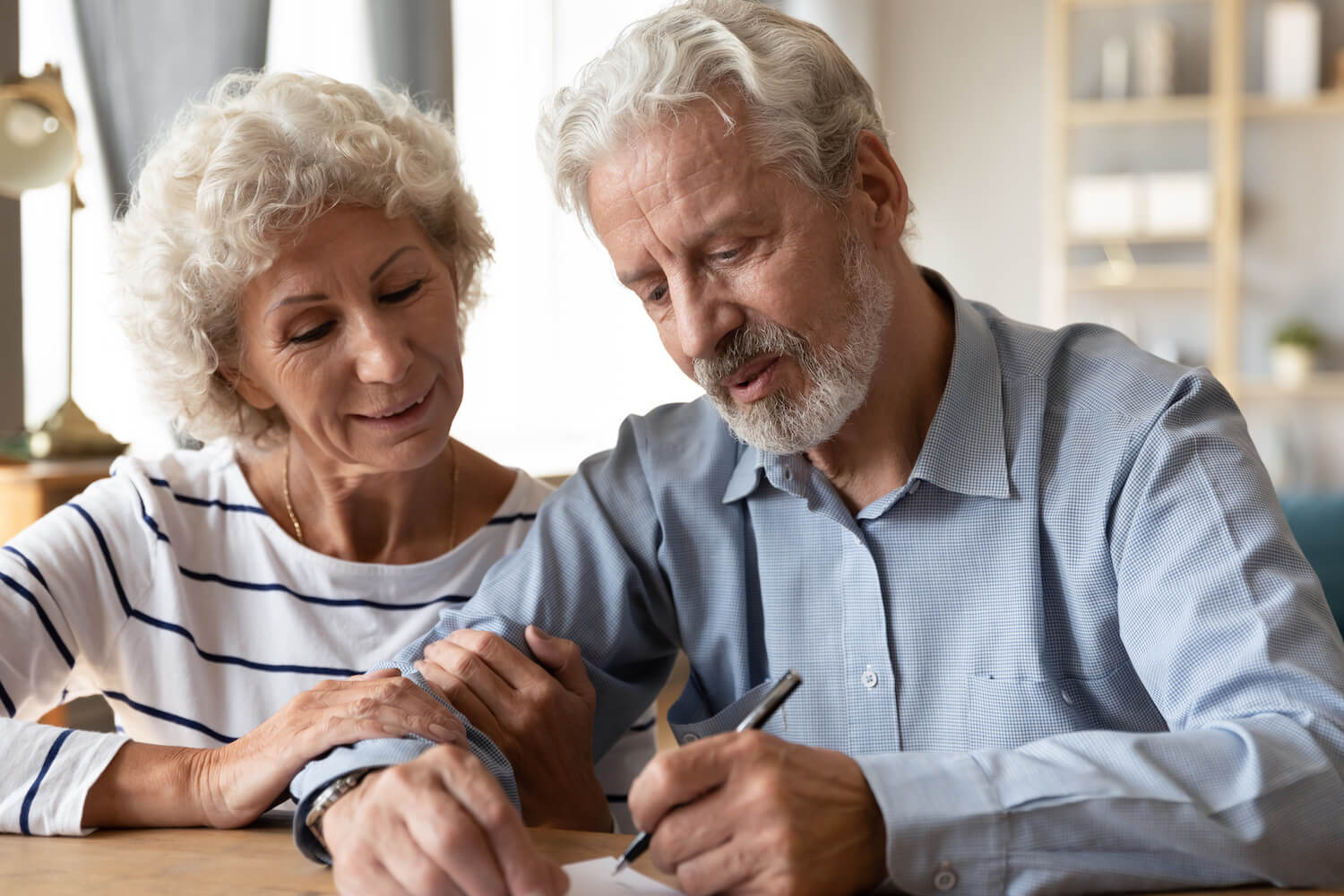 Senior couple signing legal documents together